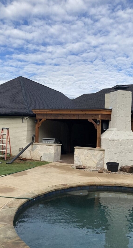 Outdoor kitchen with fireplace by Texstone Homes